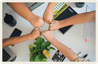 Team fist bump over desk